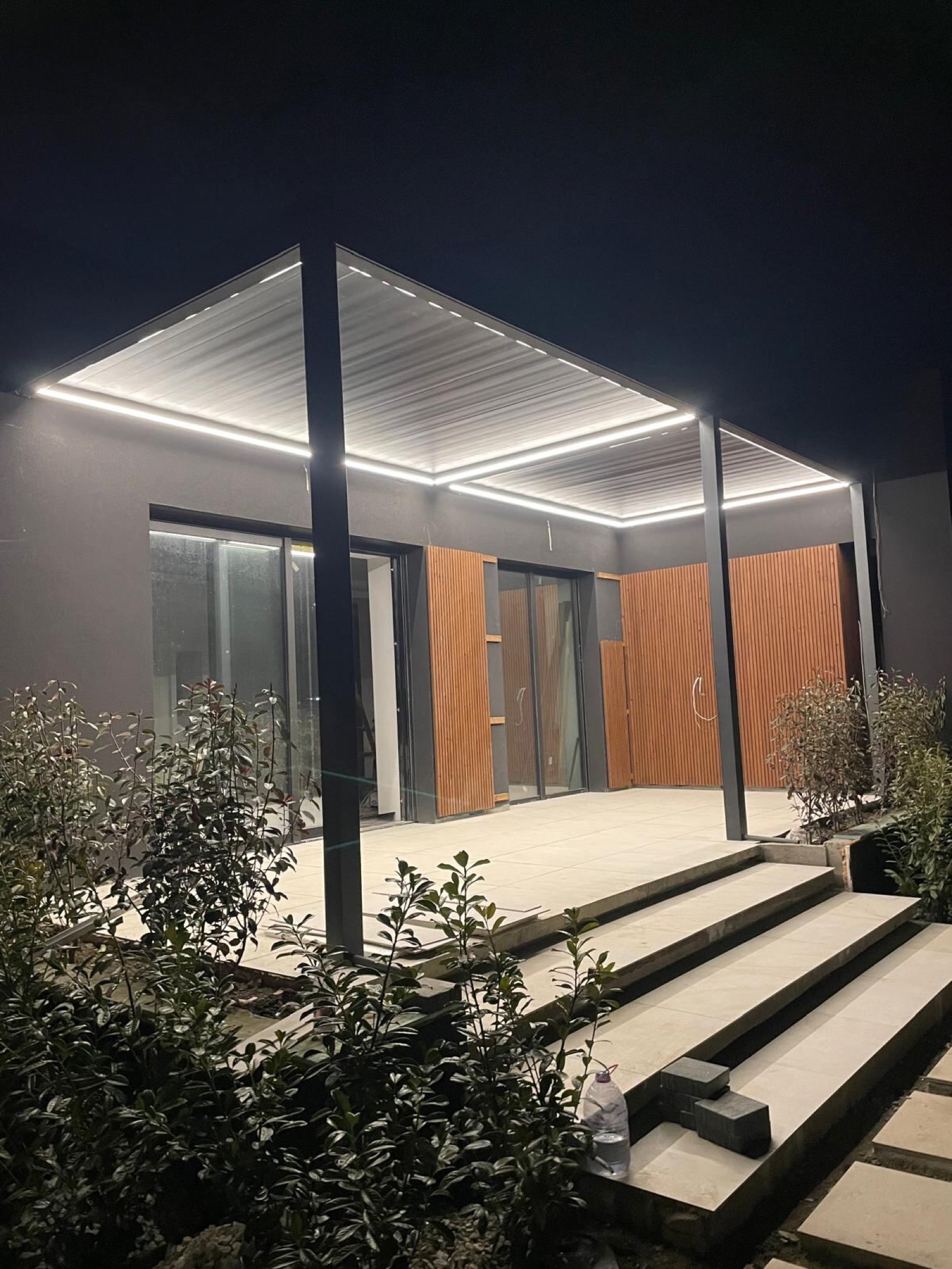 Pergola bioklimatyczna z obwodowym oświetleniem LED wieczorem